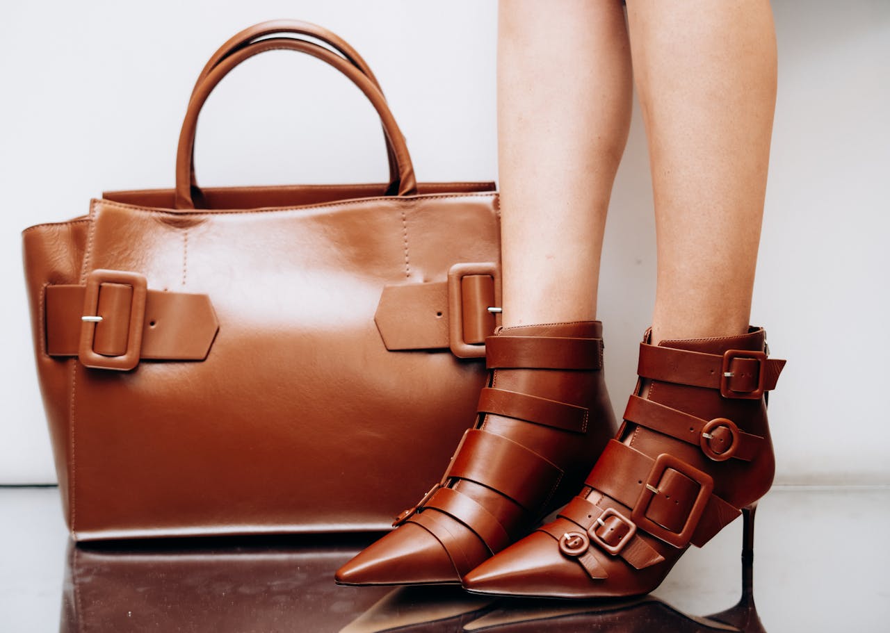 Chic brown leather boots and handbag with buckles, perfect for fashion-forward styling.